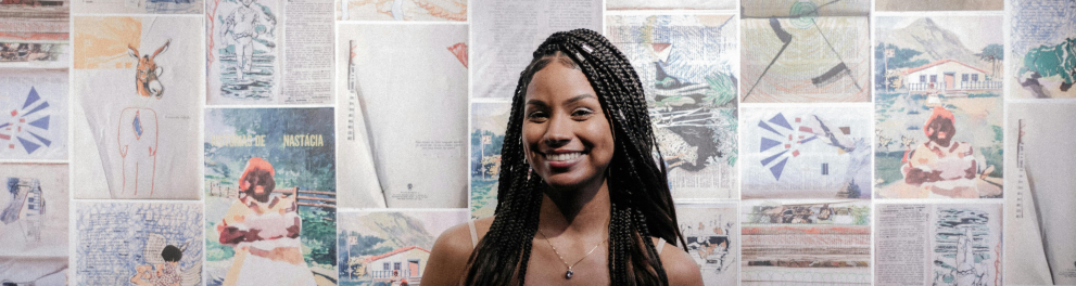 A imagem mostra uma mulher negra sorrindo para a foto