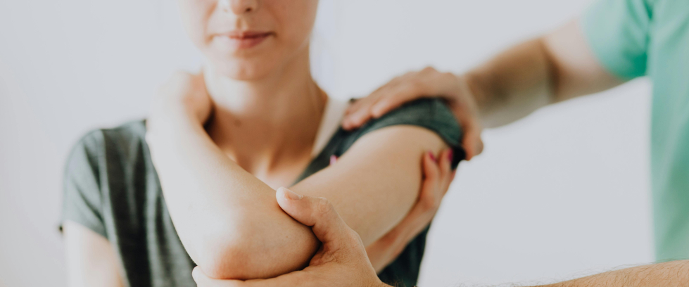 A imagem mostra um profissional da saúde ajudando uma mulher a se alongar
